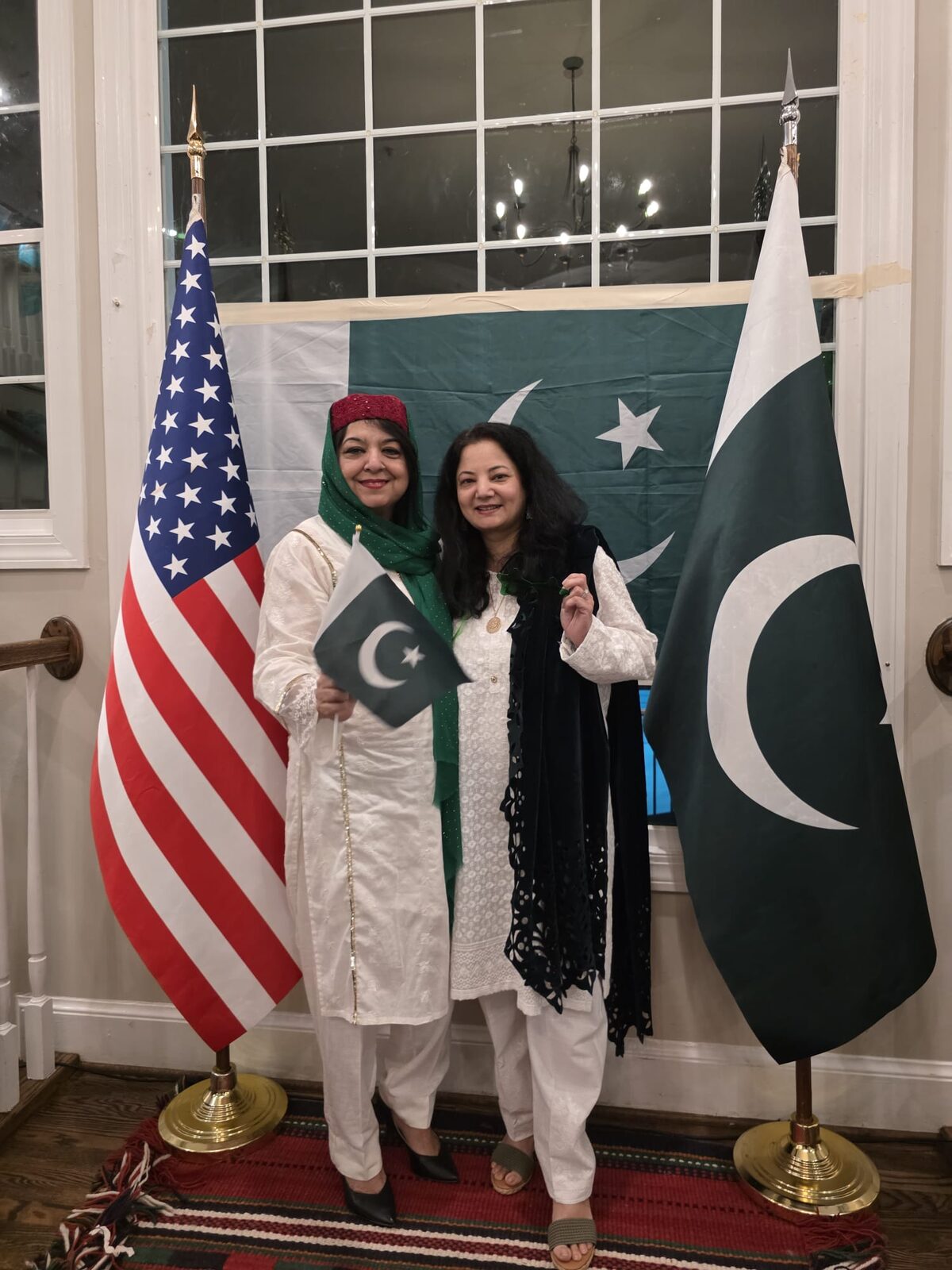 PANI members at a community event, standing with American and Pakistani flags